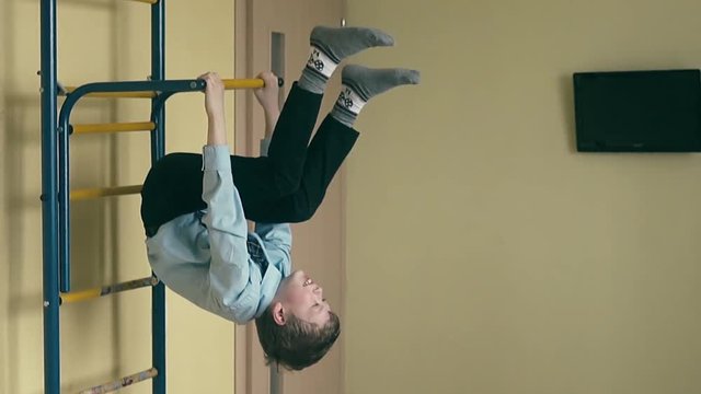 Slow motion: boy, in school uniform, makes coup on the sports ladder.