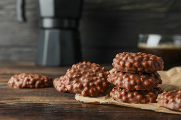 Chocolate cookies and cup of coffee on wooden table against dark background, space for text
