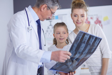 Fototapeta premium Portrait of a cute little girl and her doctor at hospital