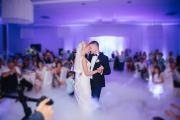 First dance of stylish wedding couple. Handsome groom and elegant bride in the restaurant