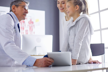 Obraz premium Little girl with her mother at a doctor on consultation
