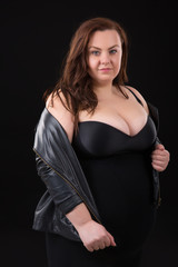 Beautiful young woman plus size with big bust in underwear and Leather Jacket n black background