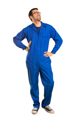 A full-length shot of a Painter man posing with arms at hip and laughing on isolated white background