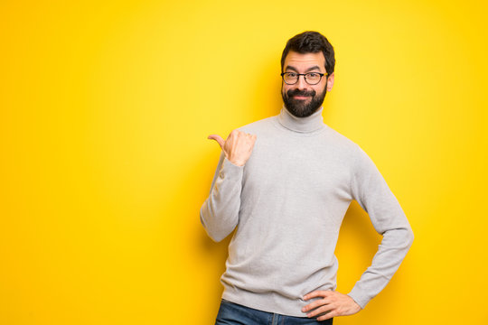 Man with beard and turtleneck pointing to the side to present a product