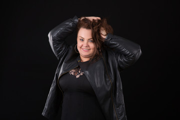 Beautiful young woman plus size with big bust in underwear and Leather Jacket n black background