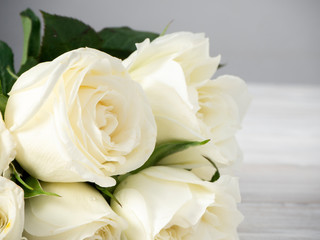 Obraz na płótnie Canvas White roses on a white wooden table