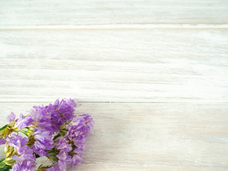 Bouquet from purple statice flowers on a white wooden table