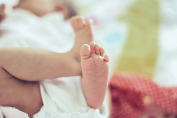 closeup of legs of a newborn baby lying on a blanket in the crib