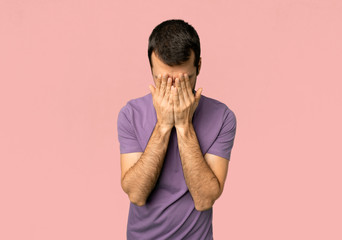 Handsome man with tired and sick expression on isolated pink background