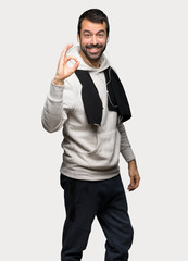 Sport man showing an ok sign with fingers over isolated grey background