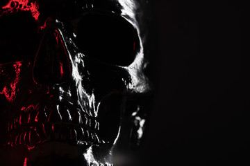 Shining skull head on dark background with neon red light. Halloween celebration, glamour, style...