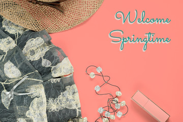 Flat lay feminine trendy fashion clothes and accessories collage, Welcome Springtime text on coral, top view. Spring concept