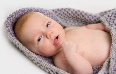 baby liegt in strickdecke