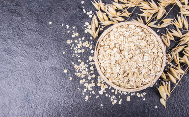 Oatmeal - a component of a healthy diet, on a dark background.