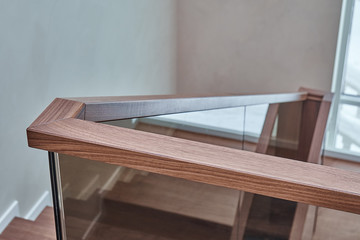 Part of wooden steps with glass railings. Walnut staircase