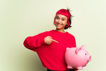 Young woman with red sweater holding a piggybank