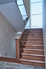 Fototapeta na wymiar Part of wooden steps with glass railings. Walnut staircase