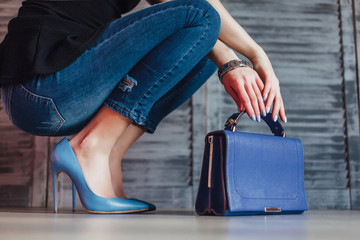 Photo of woman hands holding bag , wearing on casual jeans and blue heels!