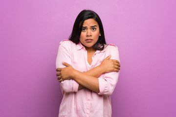 Obraz premium Young Colombian girl over purple wall freezing