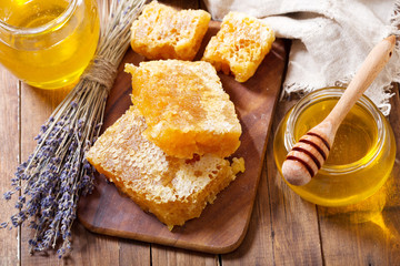 jar of lavender honey with honeycombs on wooden table