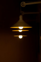 Obraz premium A row of glowing lamps hang on a black background illuminating copy space