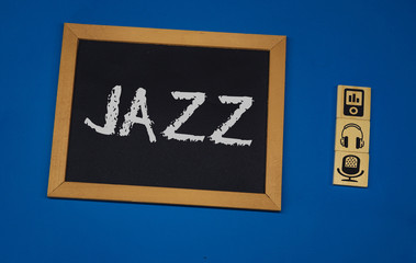 inscription JAZZ on a black board with a blue background with three wooden cubes