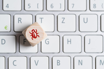 Würfel mit Bug-Symbol auf Computer Tastatur