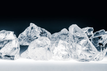 Pieces of crushed ice cubes on black background.