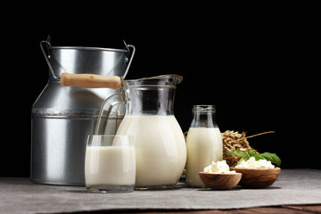 milk products. tasty healthy dairy products on a table. sour cream in a white bowl, cottage cheese bowl, cream in a a bank and milk jar, glass bottle and in a glass