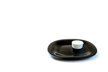 black dish with gravy boat on white background