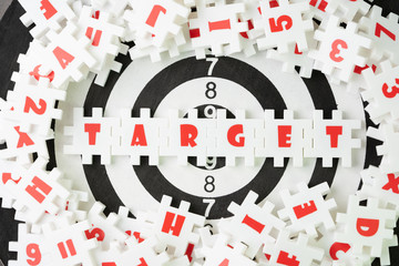 Business target plan for success strategy concept, white puzzle jigsaw with alphabet word TARGET at the center on dartboard, measurable and realistic KPI to assess business performance
