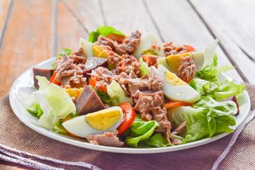 tuna salad with boiled egg, tomato slice, sweet potato and lettuce on white dish. Healthy food for loose weight, high fiber and low fat.