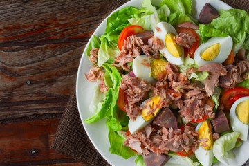 Top view tuna salad with boiled egg, tomato slice, sweet potato and lettuce on white dish. Healthy food for loose weight, high fiber and low fat.