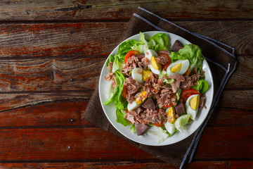 Top view tuna salad with boiled egg, tomato slice, sweet potato and lettuce on white dish. Healthy food for loose weight, high fiber and low fat.