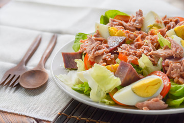 tuna salad with boiled egg, tomato slice, sweet potato and lettuce on white dish. Healthy food for loose weight, high fiber and low fat.
