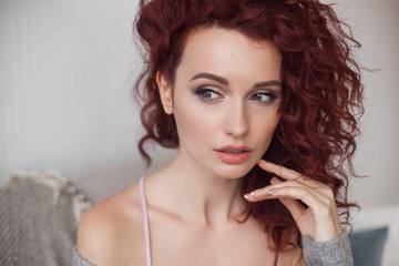 Very attractive young woman close up portrait. Beautiful female indoor. Curly haired lady. Red-haired girl. Redhead with wavy hair.