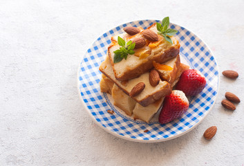 Homemade cottage cheese pudding or casserole with strawberries and almonds on a plate. Copy space. Top view