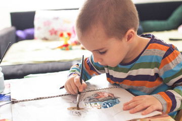 Cute boy painting and drawing at home. Children's creativity.