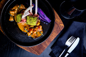 Close up of lamb chops with vegetables with a sauce of caramel, pepper and spices in a restaurant setting. © Georgii
