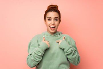 Young redhead woman with sweatshirt with surprise facial expression