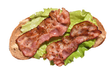 Toasted bacon on bread and a leaf of lettuce for breakfast. Close-up