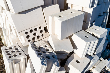 Heap of bricks from cellular concrete, white bricks, hollow bricks with hollow holes inside.