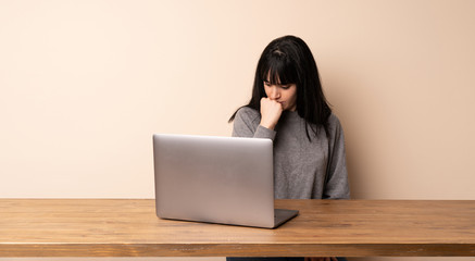 Young woman working with her laptop having doubts