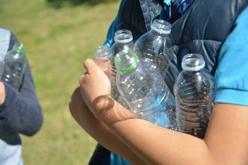 Two boys recycling plastic bottles and leftovers near the beach