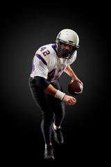 American football sportsman player on black background. Sport concept.
