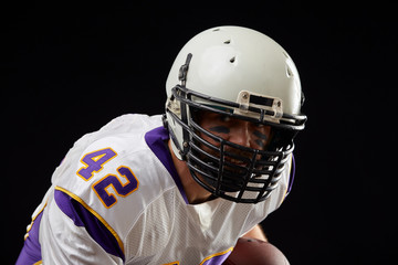 Fototapeta premium Close up portrait of American football sportsman player in action on black background. Sport concept.