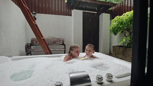 Kids with drink in tropical jacuzzi