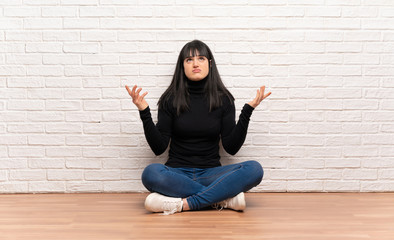 Woman sitting on the floor frustrated by a bad situation