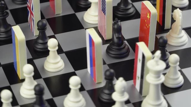 Symbols of the flags of the world on the chessboard. The concept of political game.