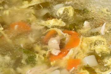 Beautiful and transparent meat broth with vegetables, cooking soup. Close-up